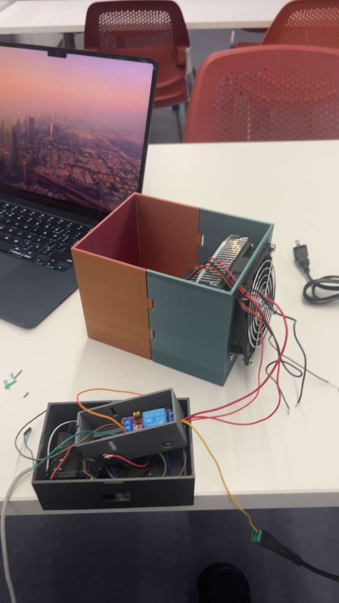The assembled insulated enclosure with a Peltier heat-sink and fan mounted on the back panel, wired through a relay module in a separate electronics box.
